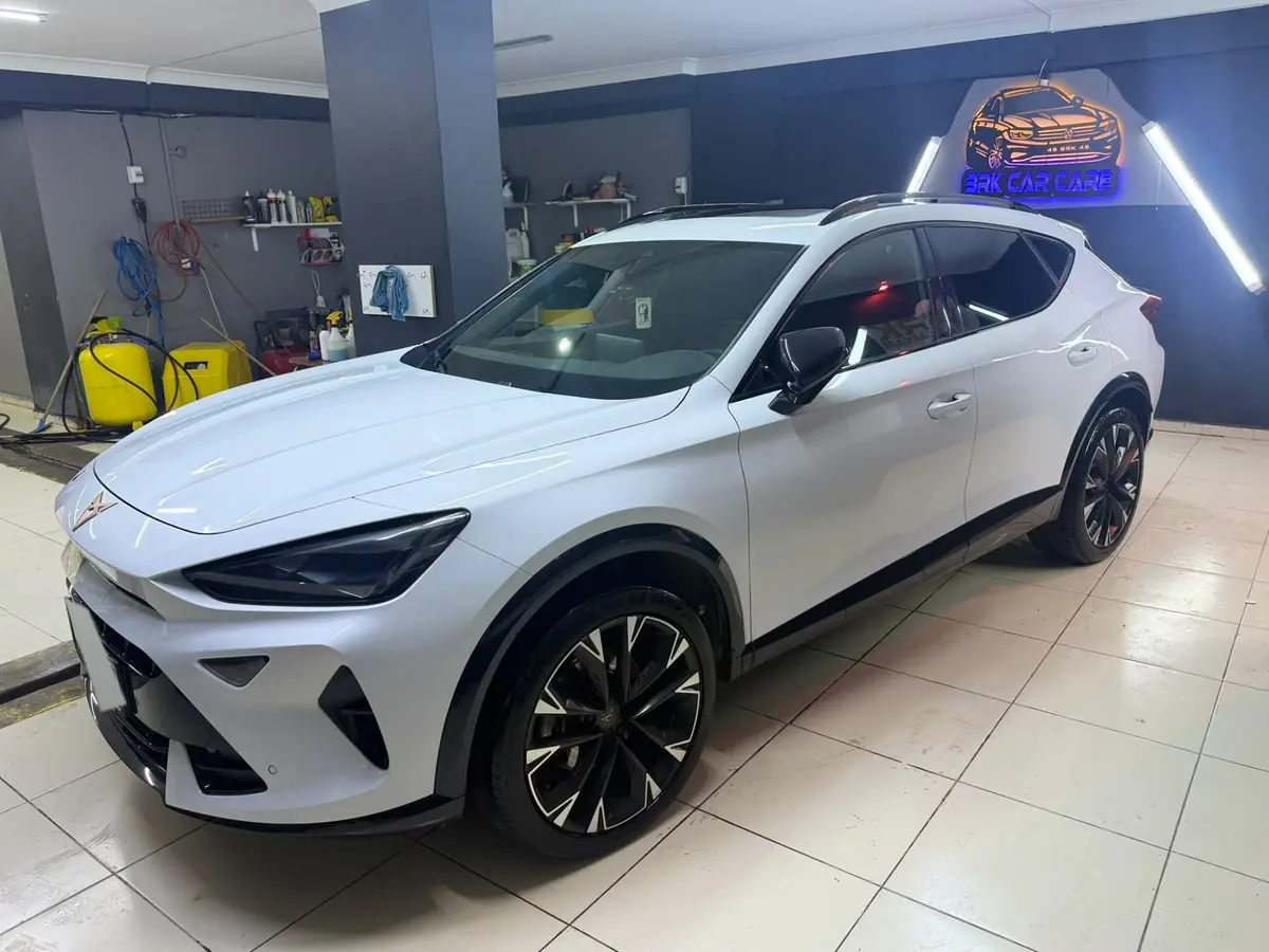 BRK Car Care stüdyosunda neon BRK CAR CARE tabelasının önünde beyaz Cupra Formentor